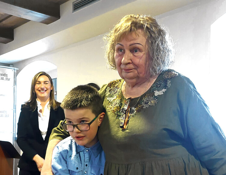 VšĮ Pagalbos centras įkūrėja ir direktorė Regina Židonienė yra mylima vaikų dienos centrų globotinių, kurių daugelis tuose centruose užaugo. Šalia - vadovės „mūsų direktoriumi“ vadinamas Pačeriaukštės vaikų dienos centro lankytojas Ajus. Nuotr. Jurgitos Morkūnienės