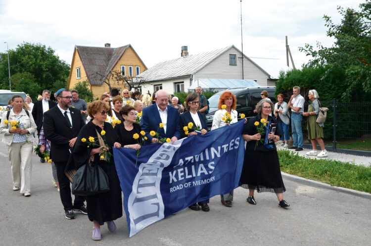 Atminties kelio eiseną į Pakamponis pradėjo svečiai iš Lietuvos bei Jungtinių Valstijų ir renginio organizatoriai. Geltoni gėlių žiedai eisenos dalyvių rankose – tai pagarbos, atminties ir vilties simbolis. Nuotr. Petro Gudo